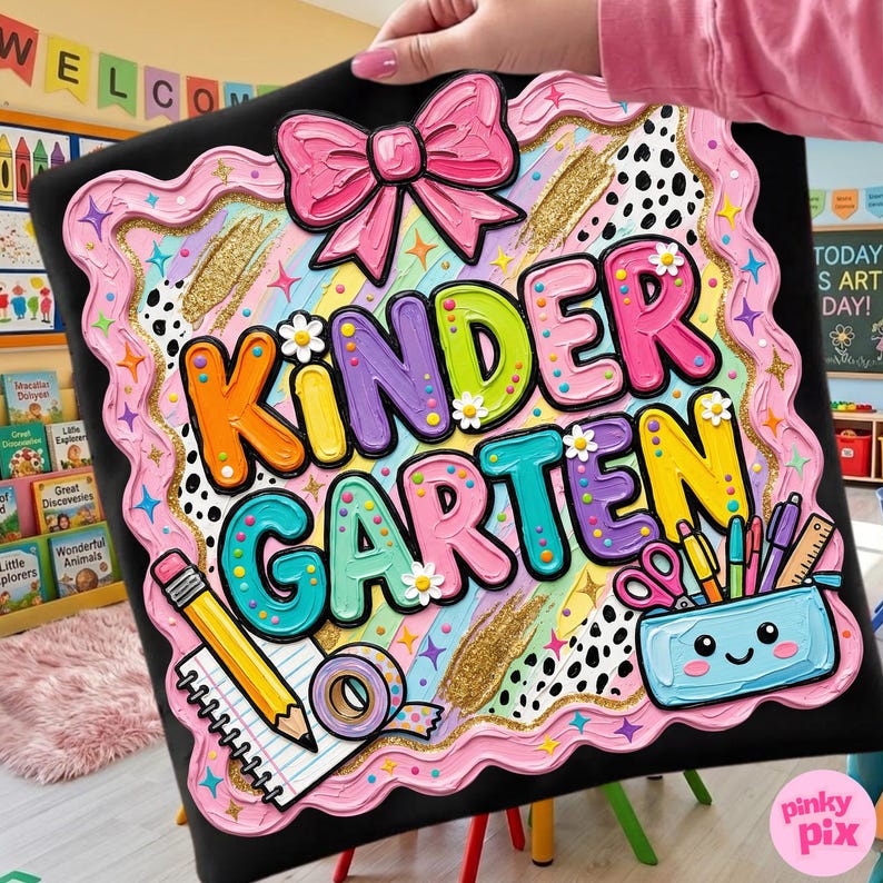 May include: A colorful "Kindergarten" sign with a pink bow, rainbow stripes, and school supplies. The sign has a black background with a pink wavy border and gold accents. The text "Kindergarten" is in large, multi-colored letters.