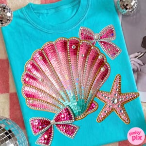 Puede incluir: Una camiseta turquesa con un gran diseño de concha con lentejuelas en tonos rosa y turquesa, adornada con perlas y pedrería. También incluye dos lazos de lentejuelas y una estrella de mar. La camiseta tiene el texto "pinky pix".