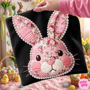 Puede incluir: Bolso tote negro con un rostro de conejo de patchwork. El diseño del conejo presenta patrones florales y de cuadros rosas, y está bordeado con perlas de imitación. El bolso lo sostiene una persona.