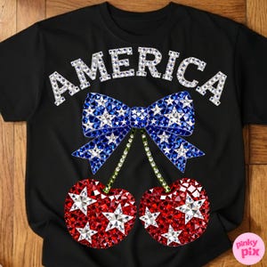 May include: Black t-shirt with the word "AMERICA" in silver rhinestones. A blue bow with white star accents and red cherries with white star accents complete the patriotic design.
