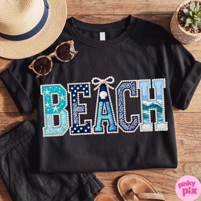 May include: Black sweatshirt with the word "BEACH" in a patchwork design. The letters are in shades of blue and white, with patterns including stars, polka dots, and paisley. A seashell and bow accent the letter "A".