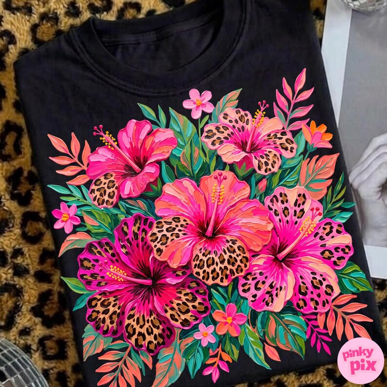 May include: Black crew neck sweatshirt featuring a vibrant floral design. The design includes pink and orange hibiscus flowers with leopard print centers, surrounded by green and orange leaves. The text "pinky pix" is in the lower right corner.
