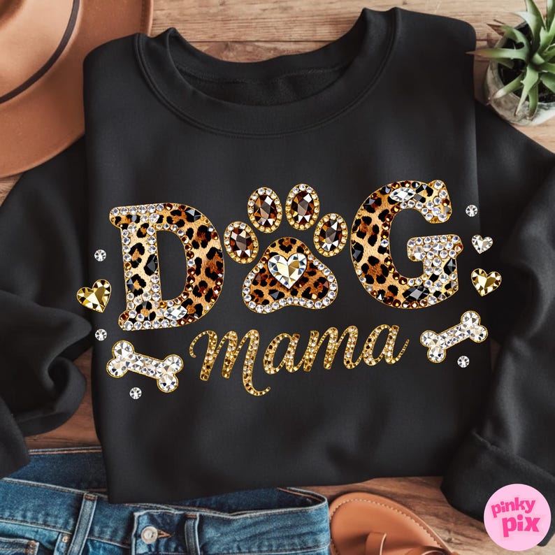 May include: Black sweatshirt with the text "DOG Mama" in a leopard print design, embellished with rhinestones. The design includes paw prints, hearts, and a bone. A stylish and comfortable apparel item for dog lovers.