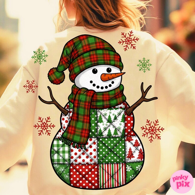 May include: Cream-colored sweatshirt featuring a whimsical snowman design. The snowman wears a plaid hat and scarf, with a carrot nose and twig arms. The body is a patchwork of red, green, and white patterns. Snowflake accents complete the festive winter theme.