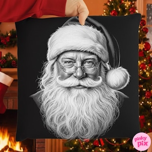 May include: Black and white decorative pillow featuring a detailed portrait of Santa Claus. The image shows Santa with a long white beard, glasses, and a traditional hat. The pillow is held up by a person's hand, with a Christmas tree and fireplace in the background.