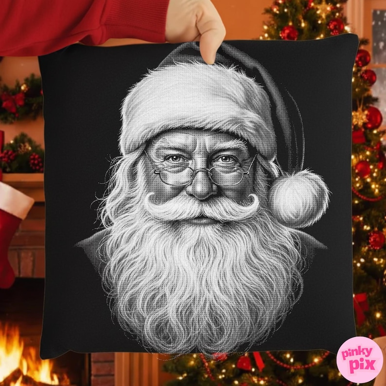 May include: Black and white decorative pillow featuring a detailed portrait of Santa Claus. The image shows Santa with a long white beard, glasses, and a traditional hat. The pillow is held up by a person's hand, with a Christmas tree and fireplace in the background.