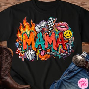 May include: Black t-shirt with a colorful graphic design that says "MAMA". The design includes flames, dice, a lightning bolt, lips, a smiley face, and barbed wire. The shirt is paired with blue jeans and a brown cowboy boot.