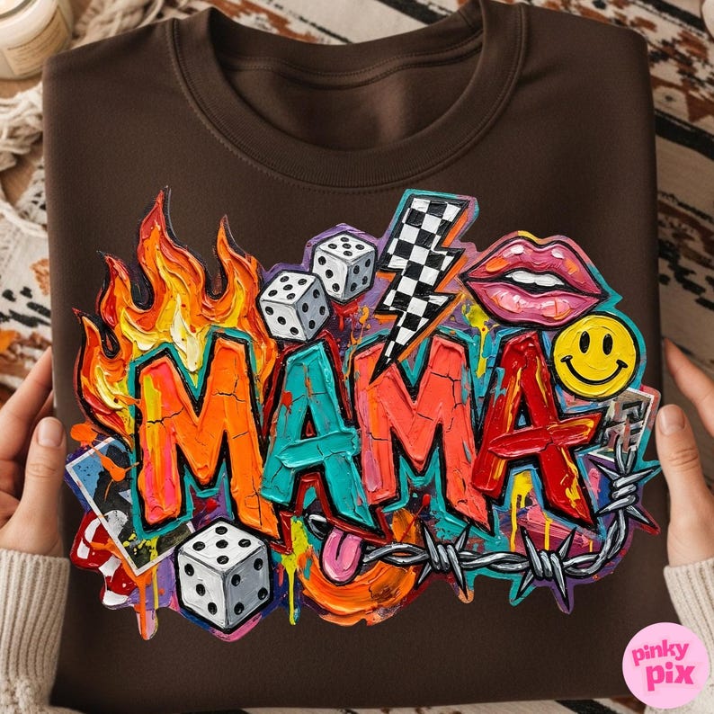 May include: Brown sweatshirt with a colorful graphic design. The design features the word "MAMA" in graffiti style, flames, dice, a lightning bolt, lips, a smiley face, and barbed wire.