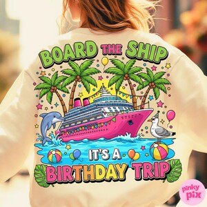 May include: Cream-coloured sweatshirt with a colourful graphic. The design features a pink cruise ship, palm trees, a dolphin, and a seagull. Text reads "BOARD THE SHIP" and "IT'S A BIRTHDAY TRIP". Balloons and stars complete the festive design.