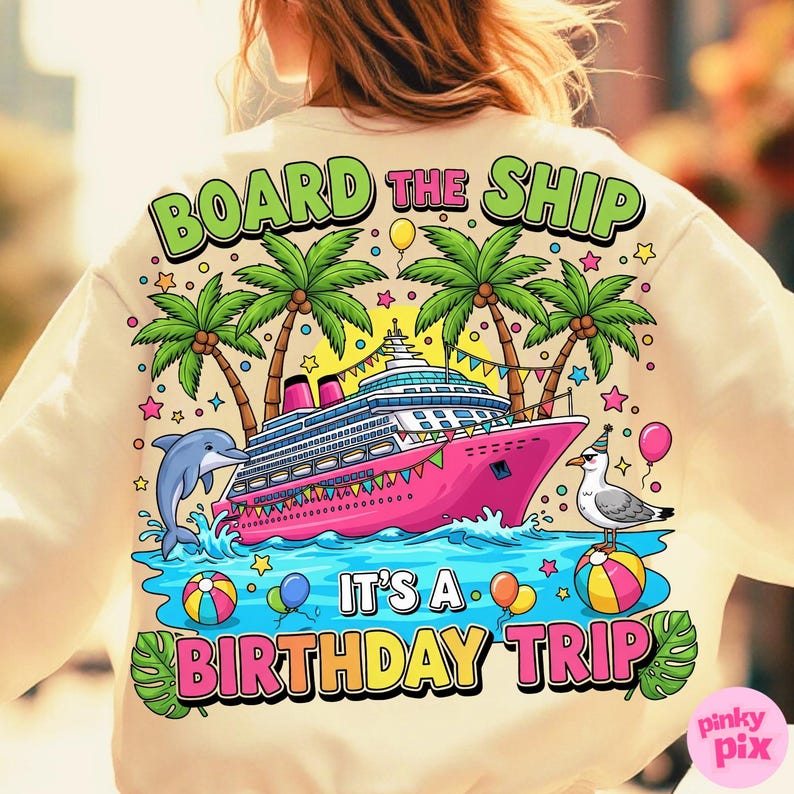 May include: Cream-coloured sweatshirt with a colourful graphic. The design features a pink cruise ship, palm trees, a dolphin, and a seagull. Text reads "BOARD THE SHIP" and "IT'S A BIRTHDAY TRIP". Balloons and stars complete the festive design.