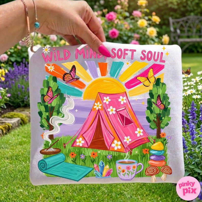 May include: A white square canvas with a colorful illustration featuring a pink tent, butterflies, and the text "WILD MIND SOFT SOUL." The design includes a sun, trees, and a yoga mat, with a cup of tea and crystals.