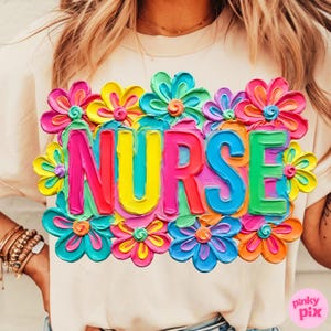 May include: A light beige t-shirt with the word "NURSE" in vibrant, multi-colored, 3D-style lettering. The word is surrounded by colorful, textured flowers in shades of pink, yellow, blue, and orange. The shirt is a casual style.