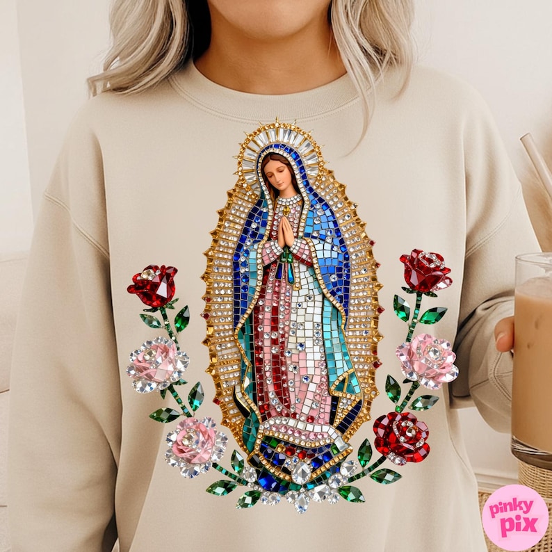 May include: Beige sweatshirt featuring a mosaic-style image of the Virgin Mary with a halo, hands clasped in prayer, and surrounded by red and pink roses. The design includes blue, red, and white colors. The sweatshirt has a round neckline.