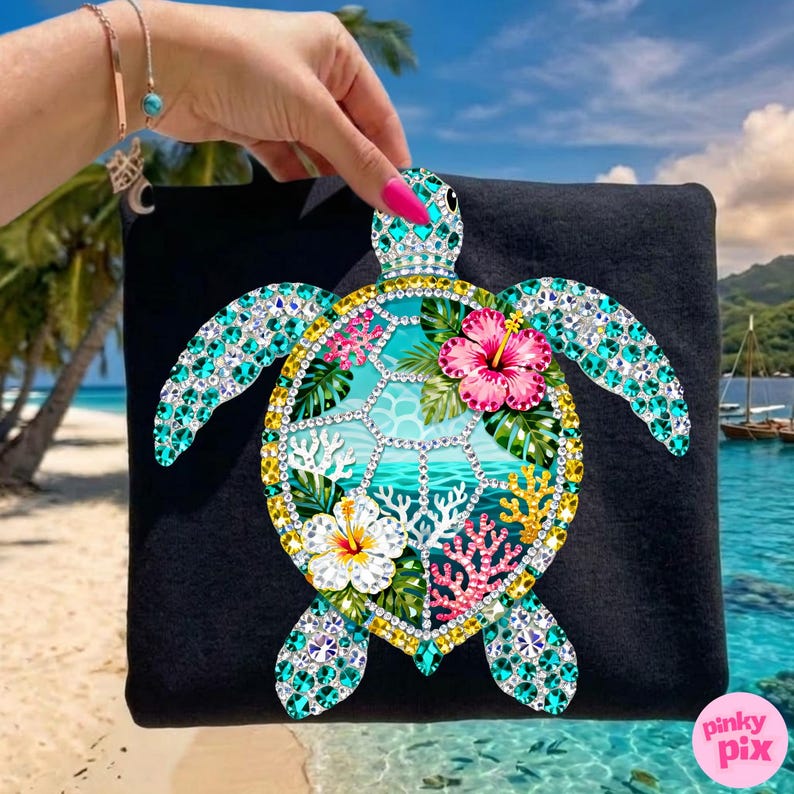 May include: Black square-shaped item with a bejeweled sea turtle design. The turtle features a turquoise and yellow shell, with a turquoise and pink floral design. The background shows a beach scene with palm trees and ocean.