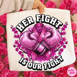 May include: A white tote bag featuring a pink ribbon, boxing gloves, and floral accents. The text reads "HER FIGHT IS OUR FIGHT" in bold, black letters. The design includes a pink leopard print background and pink flowers.