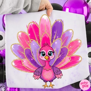 May include: A colorful cartoon turkey illustration with a vibrant display of pink and purple feathers, accented with gold glitter. The turkey has large blue eyes and is set against a white background. The image is held by a person's hand.