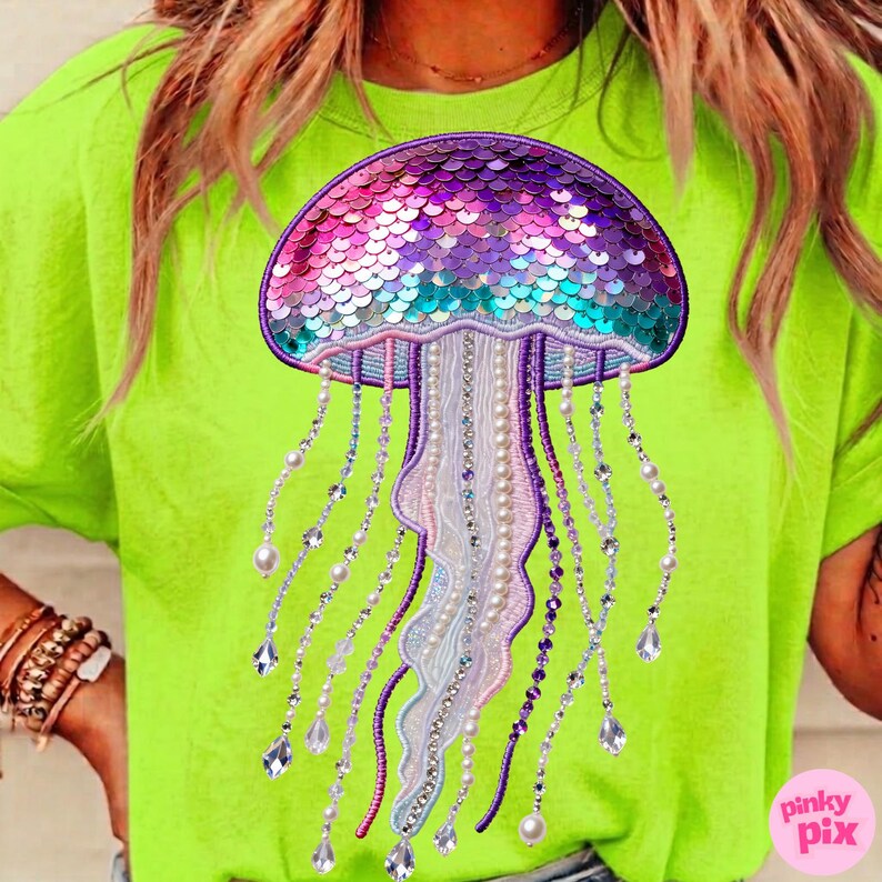 May include: A neon green t-shirt featuring a large, detailed jellyfish design. The jellyfish is adorned with iridescent sequins in shades of purple, teal, and pink. Long, beaded strands with pearls and crystals hang from the jellyfish.