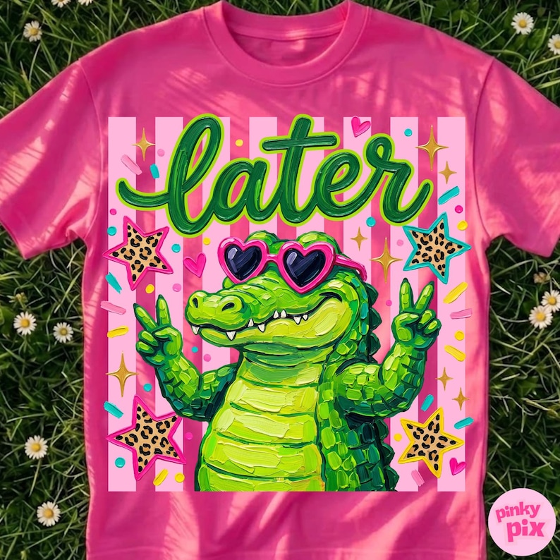 May include: Pink t-shirt featuring a cartoon alligator wearing heart-shaped sunglasses and giving a peace sign. The word "later" is written in green script above the alligator. The design includes stars and stripes.
