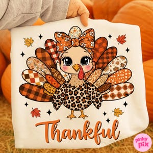 Könnte beinhalten: Ein weißes Thanksgiving-Motiv mit einer Cartoon-Truthahnfigur mit gemusterter Schleife, Federn und einem Brustfell im Leopardenmuster. Das Wort "Thankful" steht in orangefarbener Schrift darunter. Herbstblätter und Sterne umgeben den Truthahn.