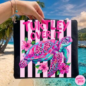 May include: Black tote bag with a pink and white striped background. The bag features a colorful sea turtle design with the text "Turtley Over It". The turtle is pink, teal, and purple, with pink hibiscus flowers.