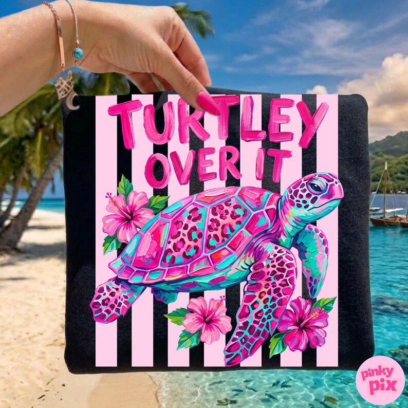 May include: Black tote bag with a pink and white striped background. The bag features a colorful sea turtle design with the text "Turtley Over It". The turtle is pink, teal, and purple, with pink hibiscus flowers.
