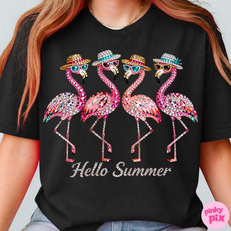 May include: Black t-shirt featuring four bejeweled flamingo illustrations wearing hats and sunglasses. The flamingos are pink with crystal accents. The text "Hello Summer" is displayed in silver script below the flamingos.