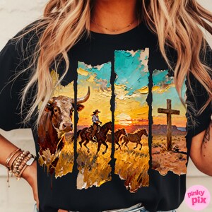 May include: Black t-shirt featuring a Western-themed graphic. The design includes a bull, a cowgirl on horseback, and a cross against a sunset backdrop. The artwork has a textured, painted appearance.