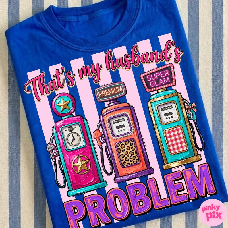 May include: Royal blue t-shirt with a graphic design featuring three stylized gas pumps in pink, orange, and teal. The text reads "That's my husband's PROBLEM" in a playful font.