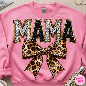 Pu&ograve; includere: Felpa rosa con la scritta "MAMA" in lettere gioiello. Le lettere "M" e "A" sono incrostate di strass trasparenti, mentre le altre lettere "M" e "A" sono nere. Un fiocco leopardato con strass &egrave; centrato sotto.