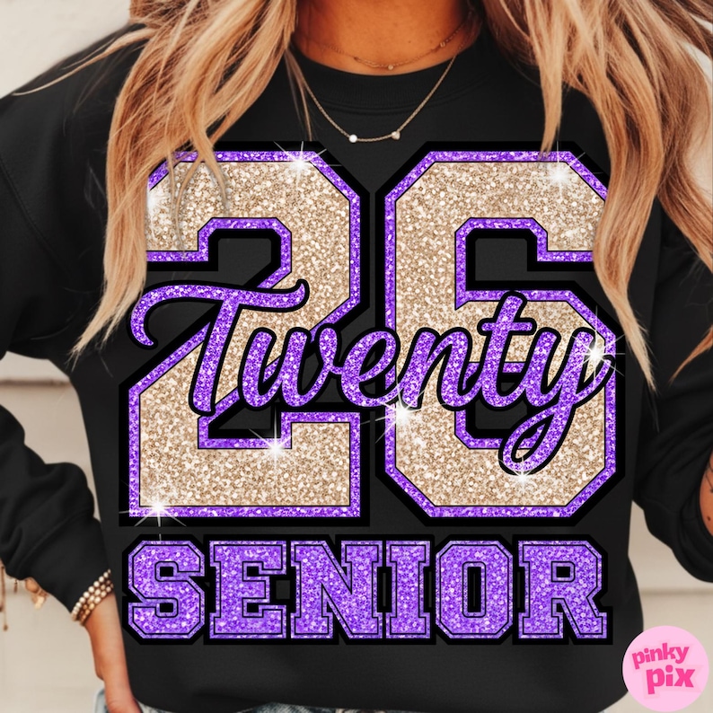 May include: Black sweatshirt with a glittery gold and purple graphic. The graphic features the number "26", the word "Twenty", and the word "SENIOR" in a collegiate style. The design has a sparkly, textured appearance.
