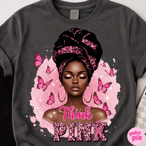 K&ouml;nnte beinhalten: Dunkelgraues Sweatshirt mit einer Grafik einer Frau, die ein schwarzes und rosa Leopardenmuster-Kopftuch und goldene Creolen tr&auml;gt. Rosa Schmetterlinge umgeben die Frau. Die Worte "Think PINK" sind in Pink gedruckt.