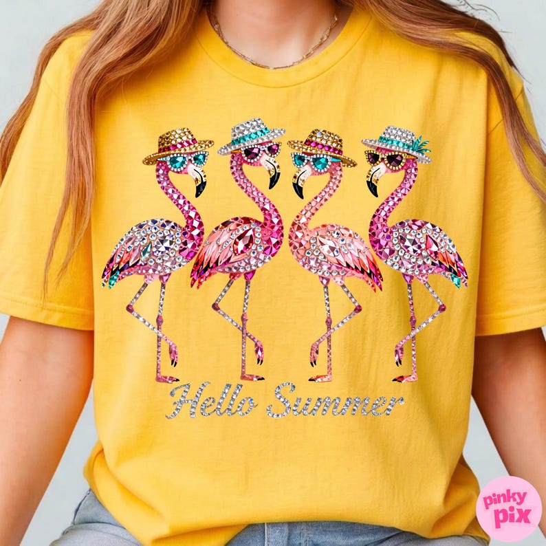 May include: Yellow t-shirt featuring four pink flamingo illustrations. Each flamingo wears sunglasses and a hat, adorned with sparkling gems. The phrase "Hello Summer" is written in silver glitter. The shirt is a casual summer wear.