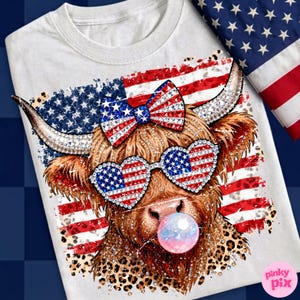 May include: White t-shirt featuring a Highland cow with patriotic sunglasses and a bow, both adorned with the American flag design. The cow is blowing a bubblegum bubble. The background includes the American flag.