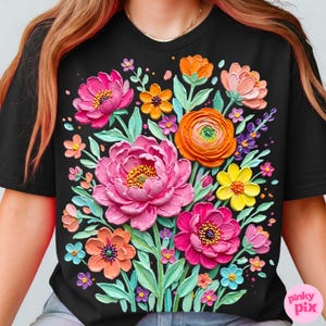 May include: Black t-shirt featuring a vibrant floral design. The design includes large pink peonies, orange, yellow, and purple flowers, and green leaves. The flowers have a textured, 3D appearance, creating a lively and colorful aesthetic.