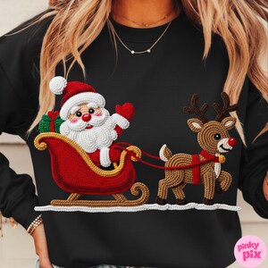 May include: Black sweatshirt featuring a detailed, textured design of Santa Claus in a red sleigh pulled by a reindeer. Santa is waving, and the reindeer has a red harness. The design is in shades of red, white, brown, and green.