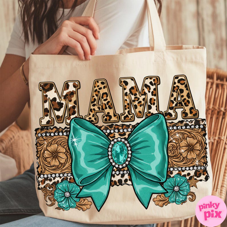 May include: A beige tote bag with the word "MAMA" in leopard print letters. The letters are outlined in black and have a turquoise bow with a rhinestone in the center. The bow is surrounded by a brown and gold floral design with rhinestones.