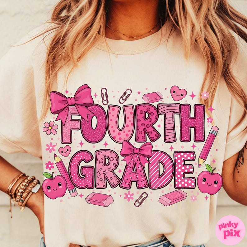 May include: A cream-colored t-shirt featuring the words "FOURTH GRADE" in large, pink, decorative letters. The design includes bows, hearts, apples, pencils, erasers, and paper clips. The words and graphics are in various pink patterns.