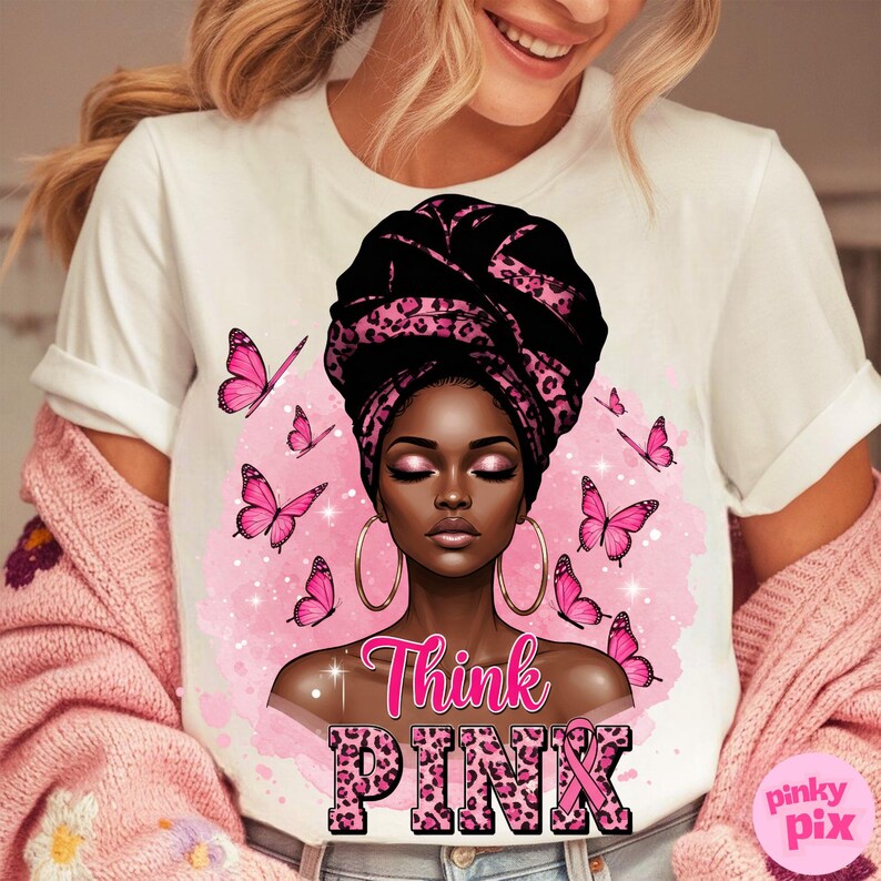 K&ouml;nnte beinhalten: Wei&szlig;es T-Shirt mit einer Grafik einer schwarzen Frau mit einem schwarz-rosa Leopardenmuster-Kopftuch und goldenen Creolen. Rosa Schmetterlinge umgeben sie. Die Worte "Think PINK" sind in rosa Leopardenmuster.