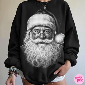 May include: Black sweatshirt featuring a detailed black and white illustration of Santa Claus. The image shows Santa with a long white beard, glasses, and a traditional hat. The design is centered on the front of the sweatshirt.