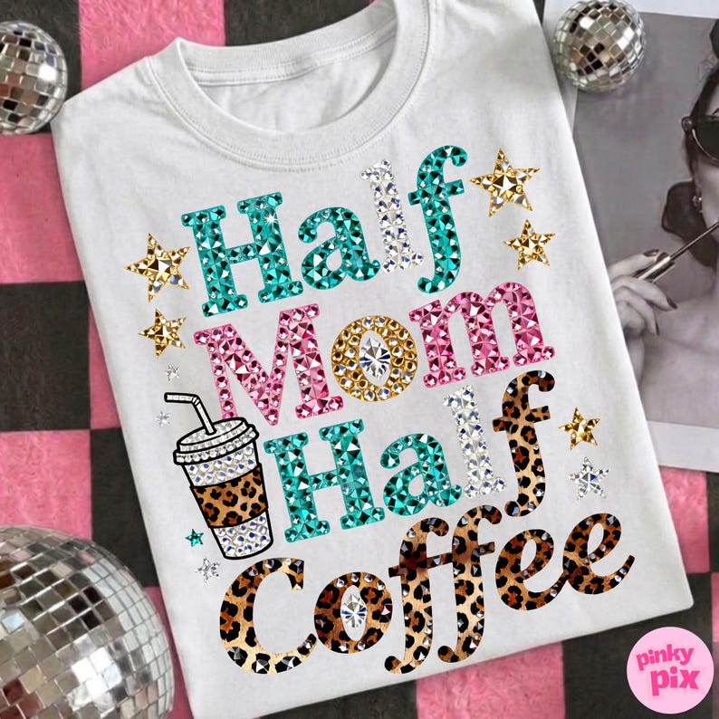 Może przedstawiać: Biała koszulka z napisem "Half Mom Half Coffee" w dżetach. Słowa są w kolorze turkusowym, r&oacute;żowym i w panterkę, z gwiazdkami i grafiką filiżanki kawy. Zabawny, codzienny top.