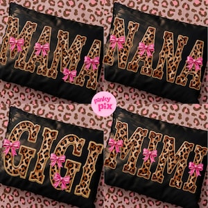 May include: Four black decorative pillows with leopard print lettering spelling "MAMA", "NANA", "GIGI", and "MIMI". Each pillow has pink bow accents. The background is a pink and brown leopard print.