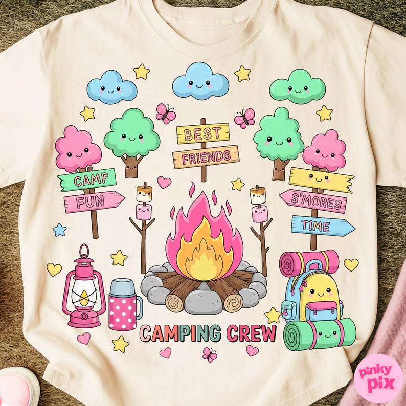 May include: A light beige t-shirt featuring a colorful camping-themed graphic. The design includes a campfire, smiling clouds, trees, and a backpack. Text includes "CAMPING CREW", "CAMP FUN", "S'MORES TIME", and "BEST FRIENDS".