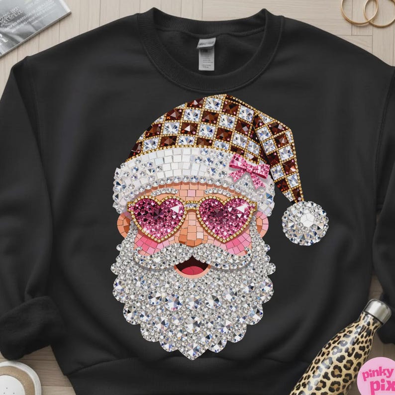 May include: A black crewneck sweatshirt featuring a graphic of Santa Claus wearing heart-shaped pink glasses. The design is composed of a mosaic of sparkling crystals in shades of brown, white, pink, and clear, forming a festive holiday pattern.
