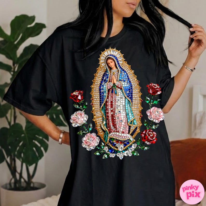 May include: Black t-shirt featuring a detailed mosaic-style image of the Virgin Mary, surrounded by red and pink roses. The image has a gold halo and is set against a blue background. The shirt has short sleeves.