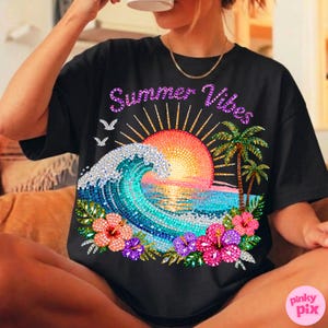 May include: Black t-shirt with a colorful "Summer Vibes" graphic. The design features a mosaic-style sunset, ocean wave, palm trees, and tropical flowers. The shirt has a relaxed fit.