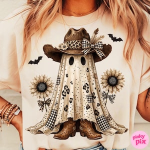 Op de afbeelding: Een crèmekleurig t-shirt met een afbeelding van een geest die een bruine cowboyhoed draagt met een luipaardprint band en een geruite strik. De geest heeft luipaardprint en geruite vlekken, geflankeerd door twee zonnebloemen en vleermuizen.