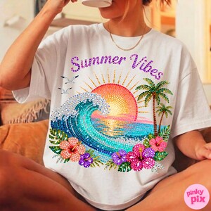 May include: White t-shirt with a colorful graphic design featuring a sunset, ocean wave, palm trees, and flowers. The text "Summer Vibes" is displayed above the graphic. The shirt is a casual, relaxed fit.