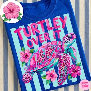 May include: A royal blue t-shirt featuring a colorful sea turtle illustration with pink, teal, and purple hues. The text "TURTLEY OVER IT" is in pink. Pink hibiscus flowers and light blue stripes complete the design.