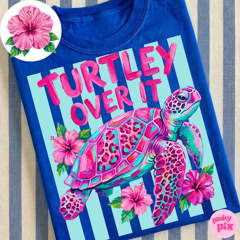 May include: A royal blue t-shirt featuring a colorful sea turtle illustration with pink, teal, and purple hues. The text "TURTLEY OVER IT" is in pink. Pink hibiscus flowers and light blue stripes complete the design.