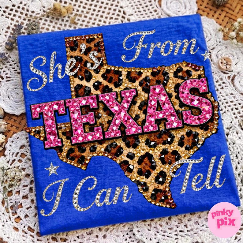 May include: A royal blue t-shirt with the phrase "She's From Texas I Can Tell". The word "TEXAS" is in pink rhinestones, and the Texas outline is leopard print.